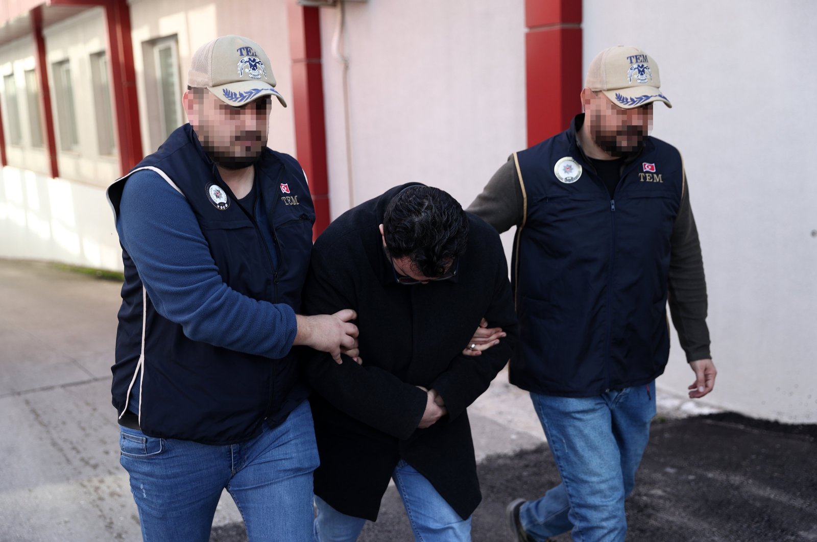 Two police arrest a FETÖ fugitive caught dodging a six-year prison sentence in the southern Adana province, Türkiye, Dec. 16, 2023. (AA Photo)