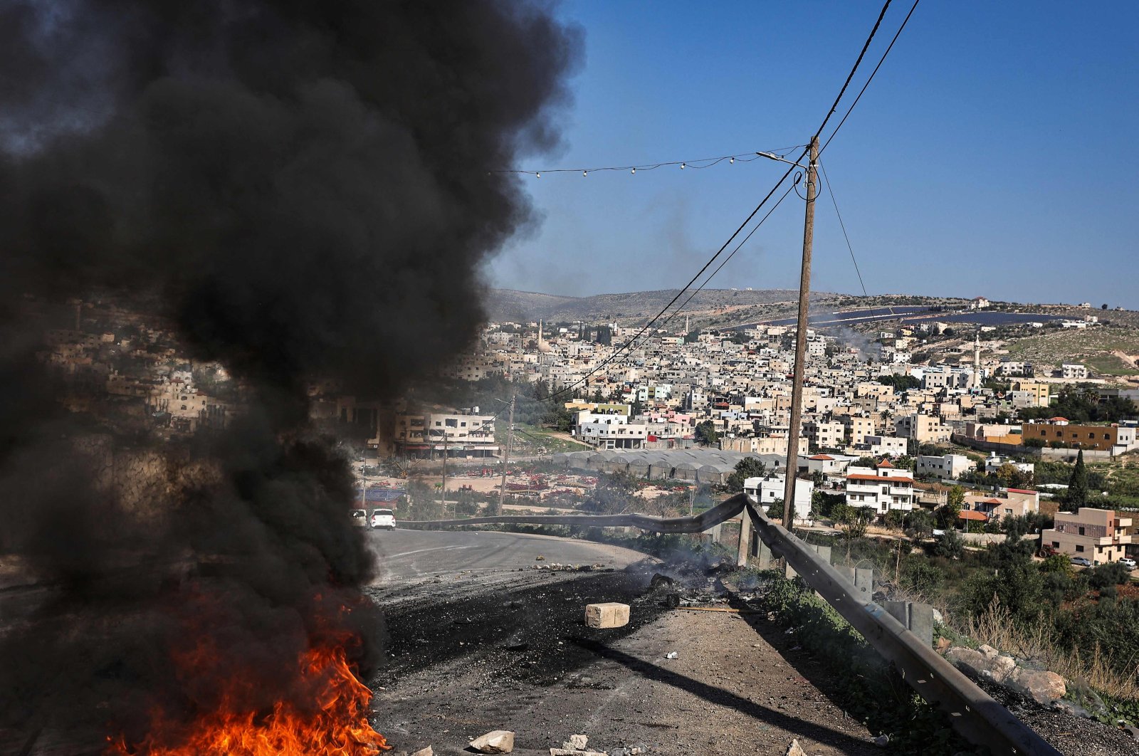 Smoke from burning tires billows on a road leading to Al-Faraa camp for Palestinian refugees near Tubas, during an Israeli raid at the camp in the occupied West Bank, Palestine, Dec. 18, 2023. (AFP Photo)