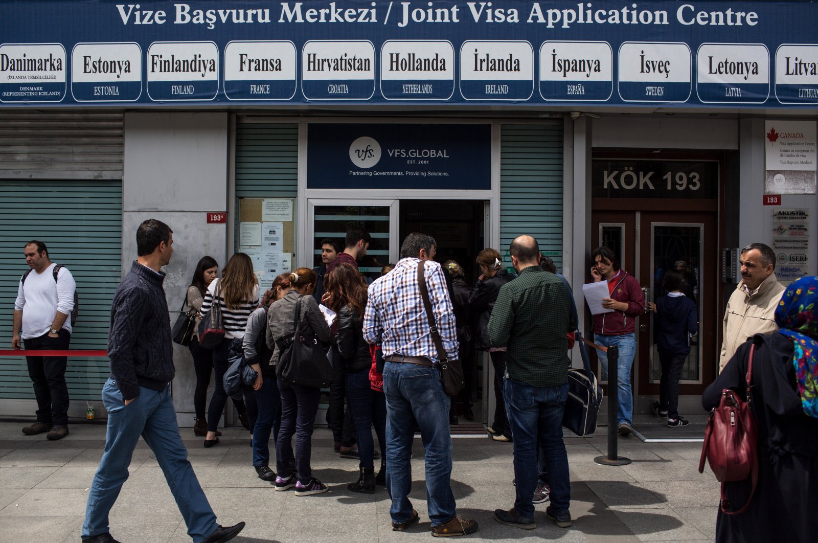 People wait outside a Joint Visa Application Center to apply for a Schengen visa, Istanbul, Türkiye, May 6, 2016. (Getty Images Photo)