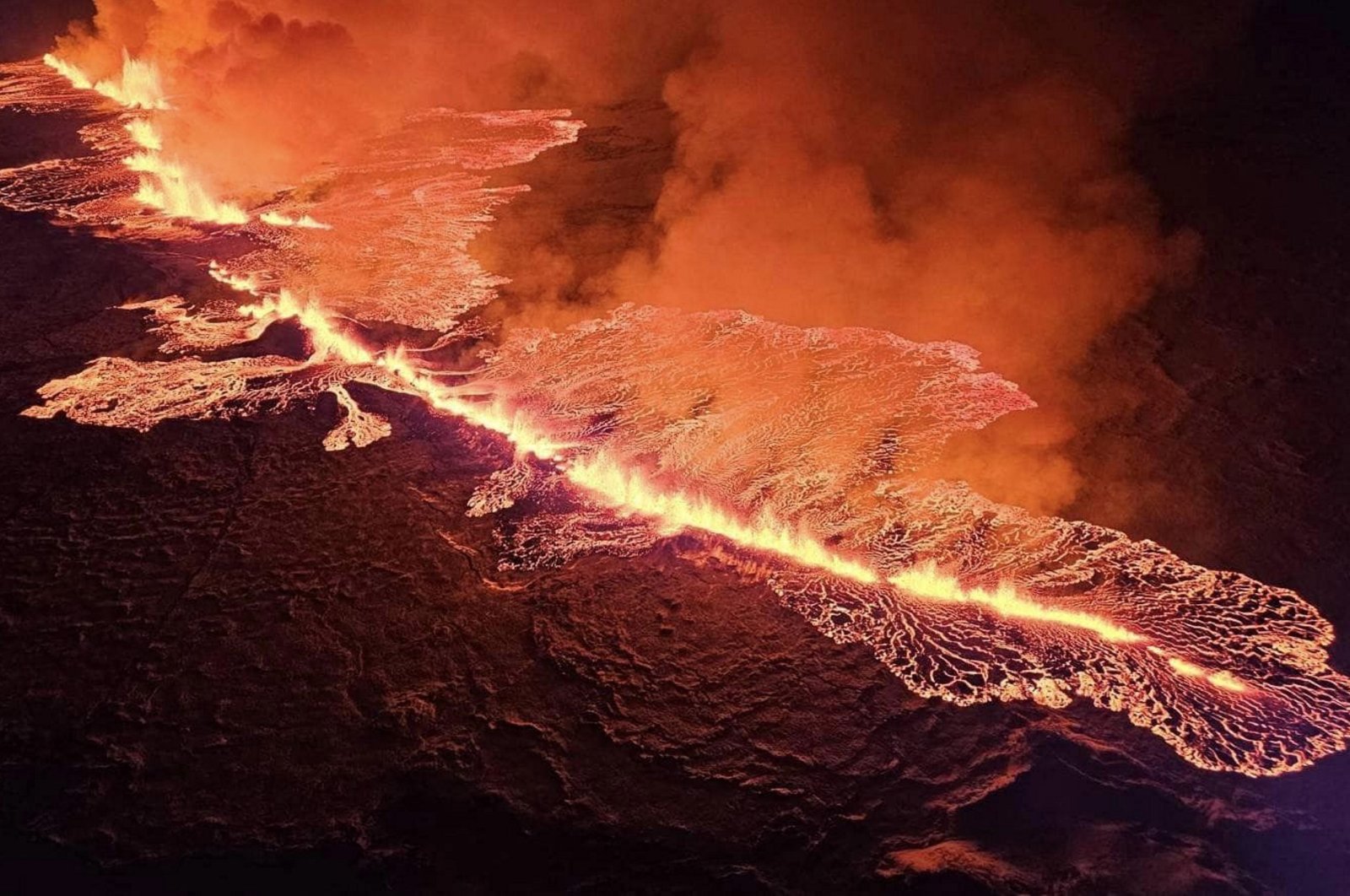 Billowing smoke and flowing lava turning the sky orange are seen during a volcanic eruption on the Reykjanes peninsula, Grindavik, Iceland, Dec. 19, 2023. (AFP Photo)