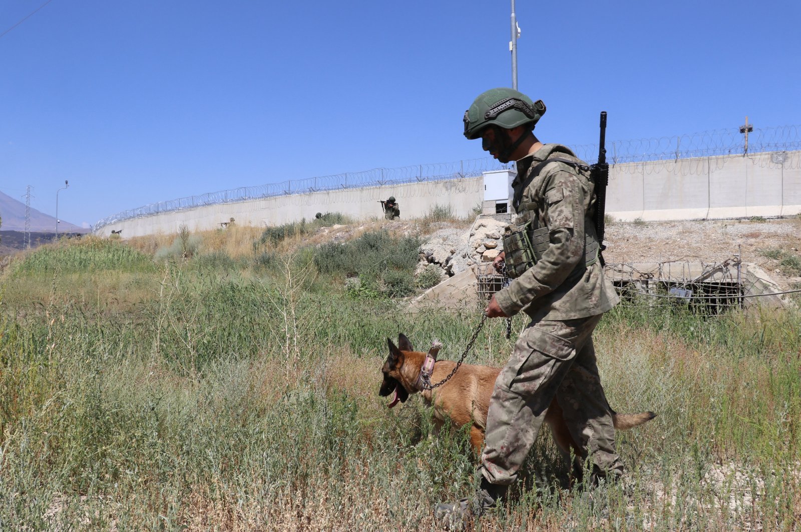 A border guard and a dog patrol near the security wall along the Turkish border to Iran, eastern Ağrı province, Türkiye, Aug. 3, 2023. (AA Photo)