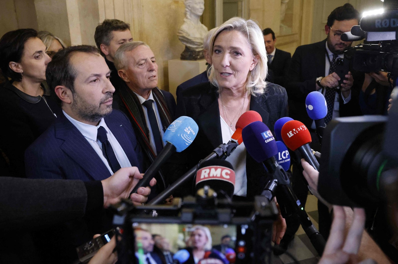 French Member of Parliament and President of the ‘Rassemblement National’ (RN) group Marine Le Pen answers journalists next to MP Sebastien Chenu (L) after a debate on the draft law to control immigration at the National Assembly in Paris on Dec. 11, 2023. (AFP Photo)