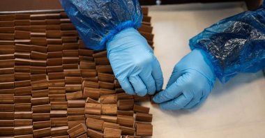 An employee making "Gianduiotto" at Guido Castagna laboratory, Turin, Italy. Dec. 12, 2023. (AFP Photo)