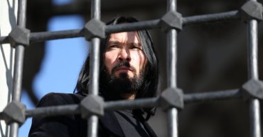 The "Turkish John Wick," Ömer Aslan, looks through a window, Konya, Türkiye, Dec. 20, 2023.