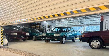Classic cars can be seen behind a half-closed garage door of the Çağıran brothers&#039; apartment terrace classic car garage, Maden, Elazığ, Türkiye, Dec. 16, 2023. (AA Photo)
