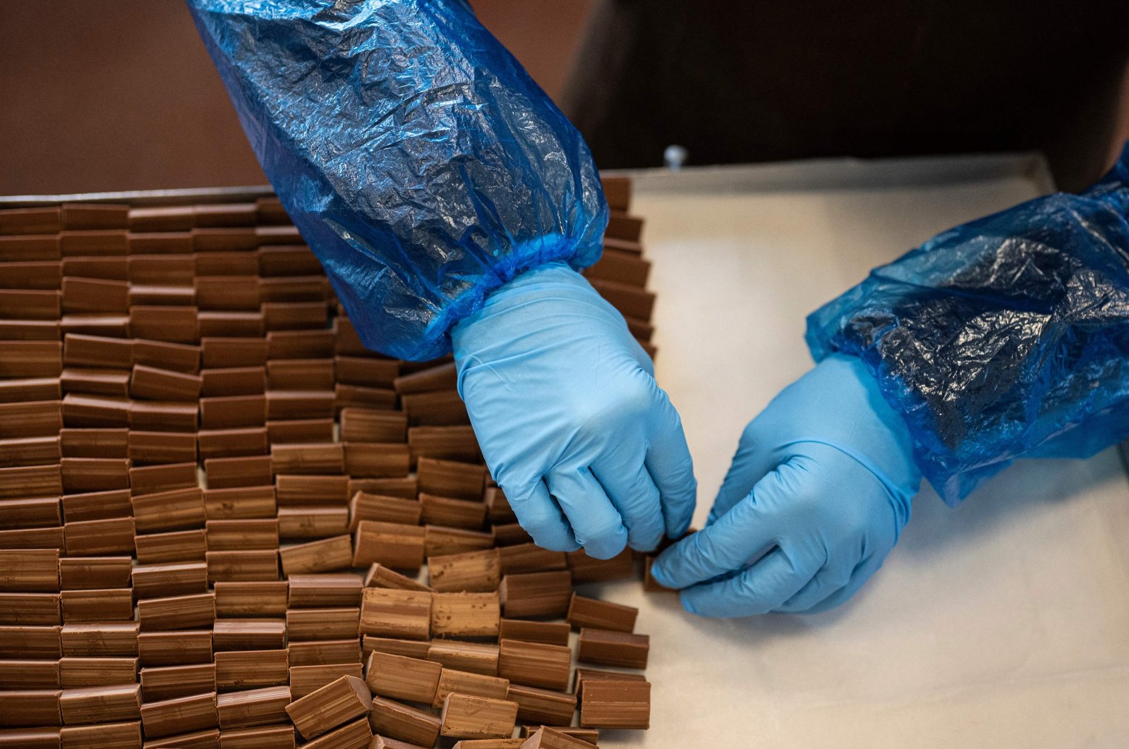 An employee making &quot;Gianduiotto&quot; at Guido Castagna laboratory, Turin, Italy. Dec. 12, 2023. (AFP Photo)