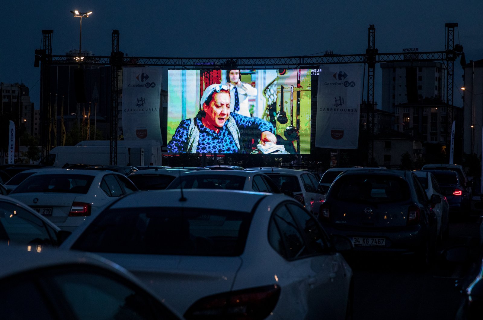 People watch a classic Turkish movie from their cars at a temporary drive-in theatre held in a shopping mall car park amid the ongoing COVID-19 pandemic, Istanbul, Türkiye, May 28, 2020. (Getty Images Photo)