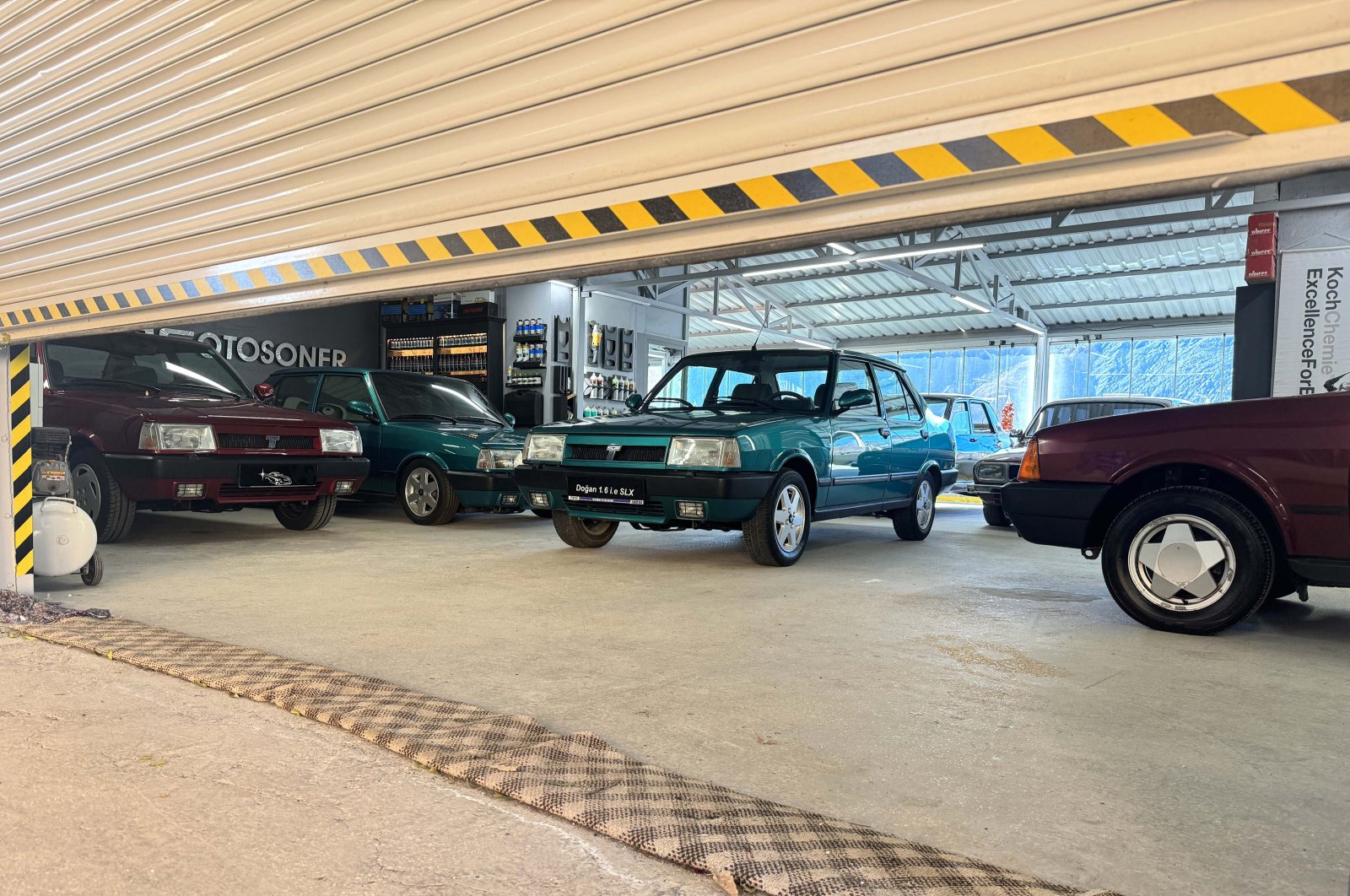 Classic cars can be seen behind a half-closed garage door of the Çağıran brothers&#039; apartment terrace classic car garage, Maden, Elazığ, Türkiye, Dec. 16, 2023. (AA Photo)