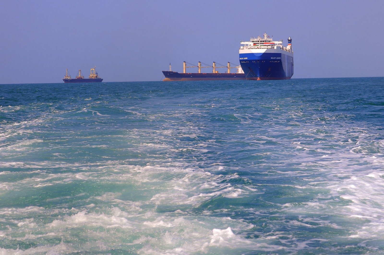 A picture taken during an organized tour by Yemen&#039;s Houthi rebels on Nov.22, 2023, shows the Galaxy Leader cargo ship (R), seized by Houthis two days earlier, approaching the port in the Red Sea off Yemen&#039;s province of Hodeida. (AFP Photo)