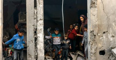 A Palestinian woman and children check debris following Israeli bombardment in Rafah, Gaza Strip, Palestine, Dec. 22, 2023. (AFP Photo)