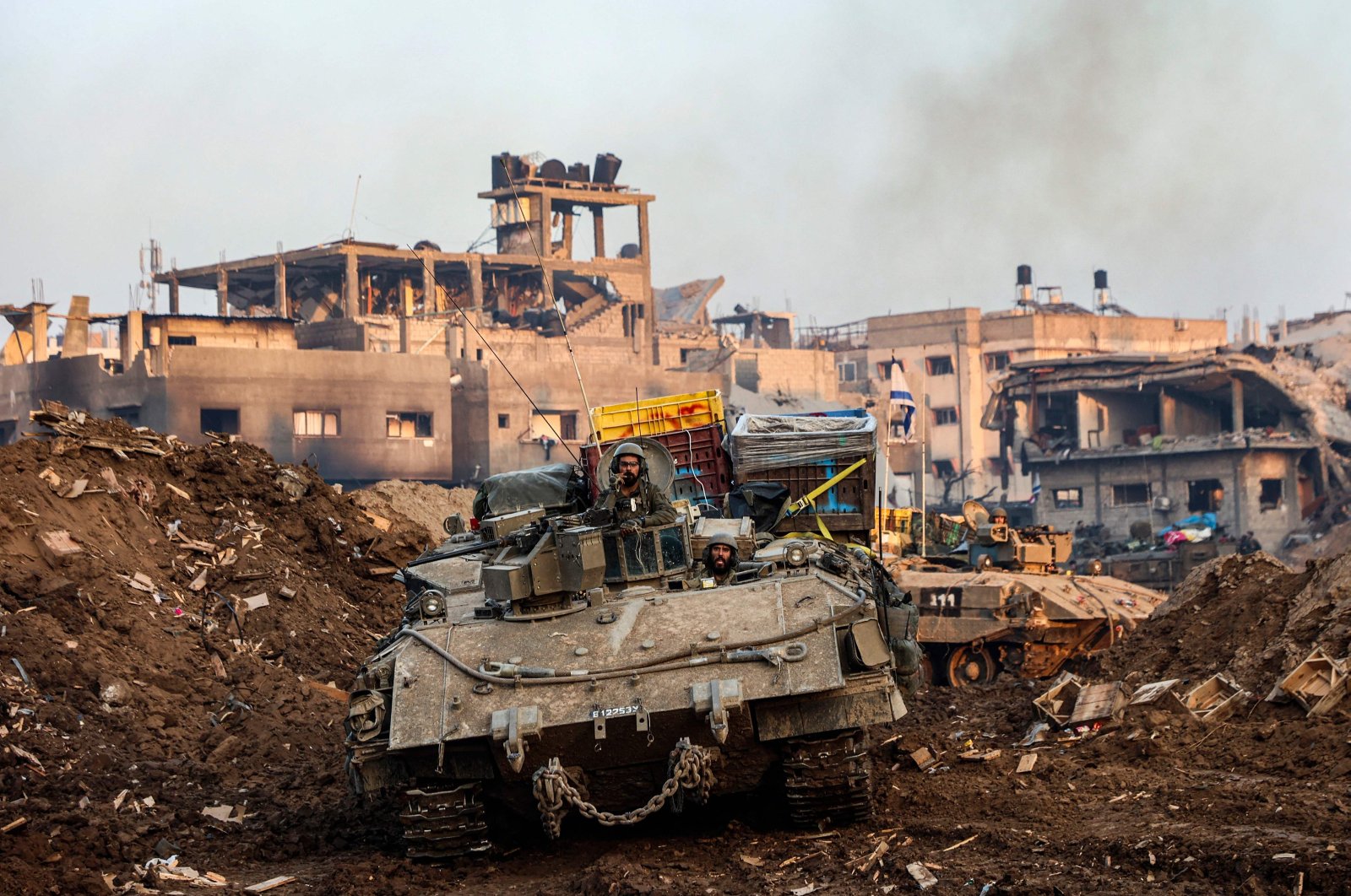 Israeli tanks rolling past damaged buildings during a military operation, Gaza Strip, Palestine, Dec. 19, 2023. (AFP Photo)