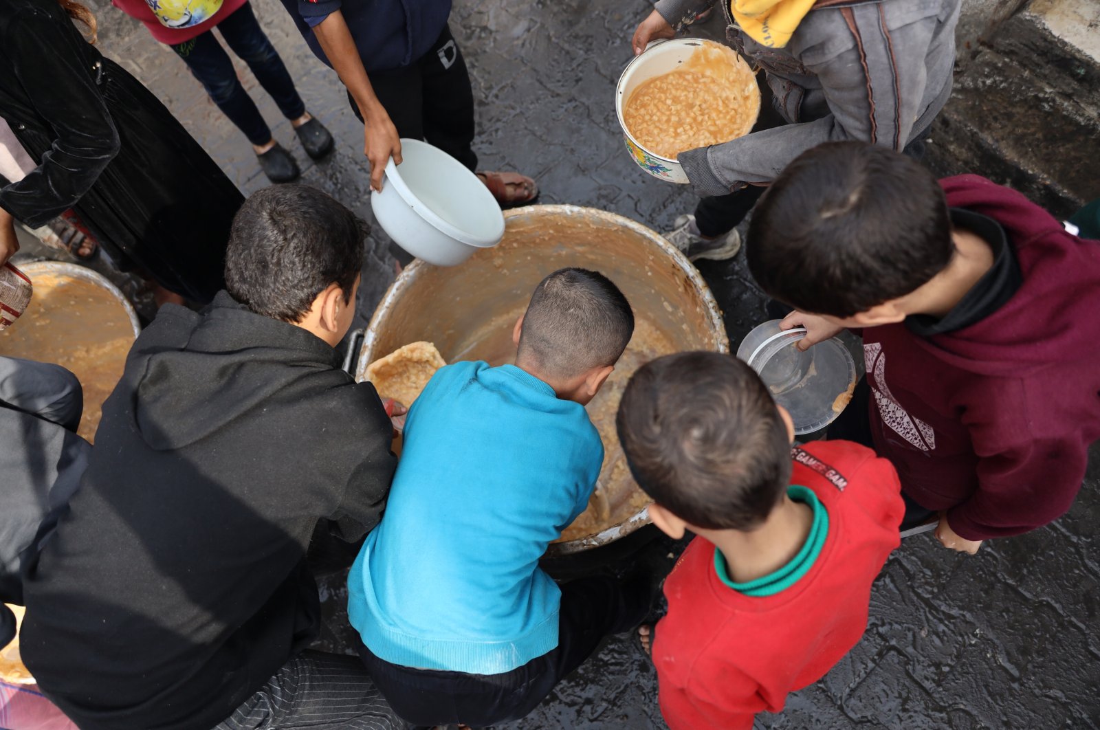 Palestinian children collect free food handouts from a volunteer hospice in Rafah, Gaza Strip, Palestine, Dec. 17, 2023. (Getty Images Photo)