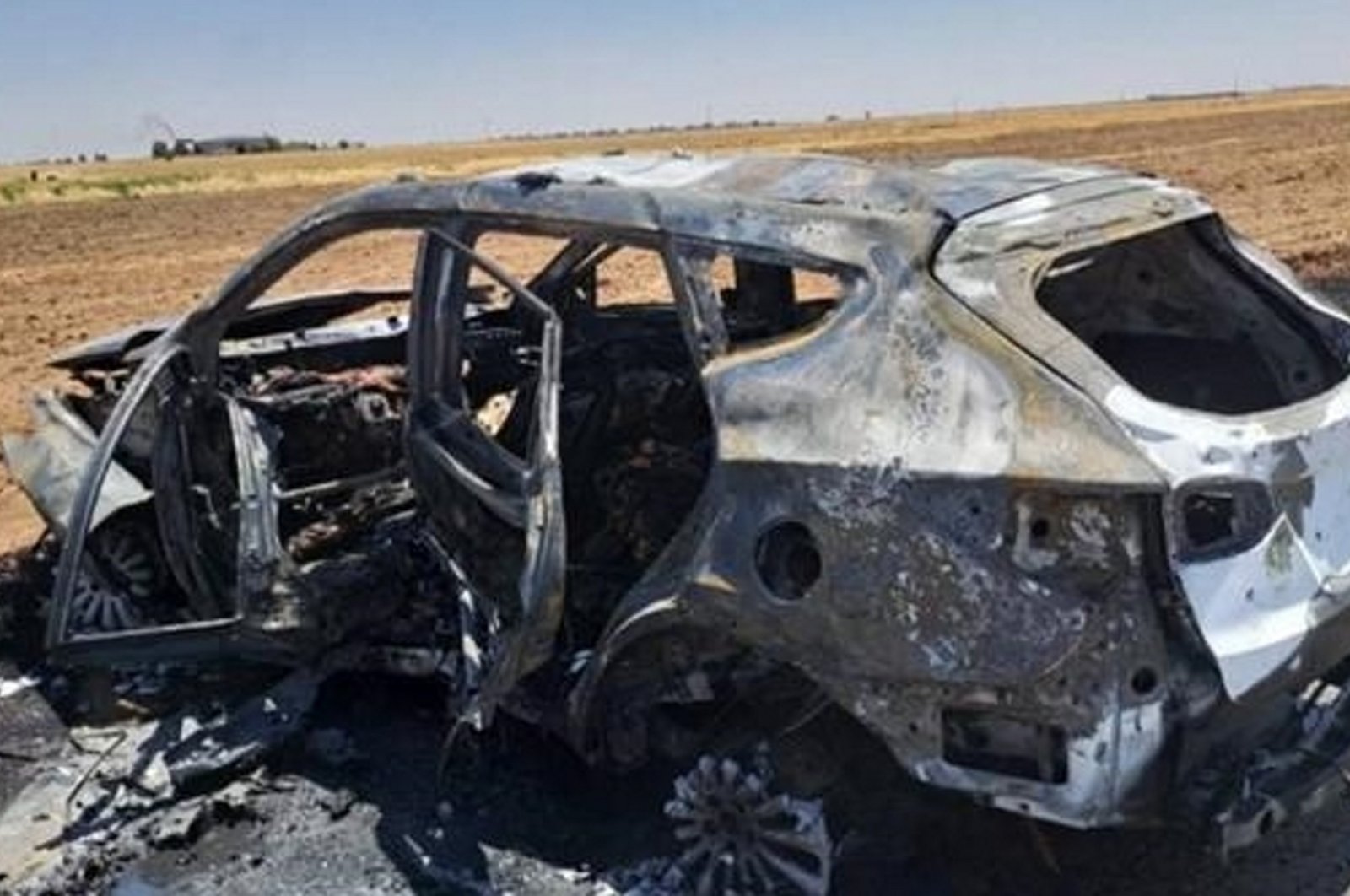 This undated photo taken in an undisclosed location shows the aftermath of a MIT strike targeting the car where &quot;Bahoz Afrin&quot; was traveling. (AA Photo)