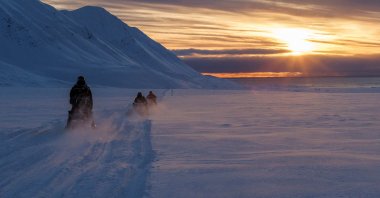 Scientists drive their snowmobiles across the Arctic toward Kongsfjord during sunset near Ny-Alesund, Svalbard, Norway, April 10, 2023. (Reuters Photo)
