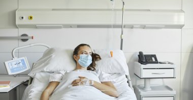 A sick woman at the hospital is staring at the windows of her room. Oct. 30, 2020. (Getty Images Photos)