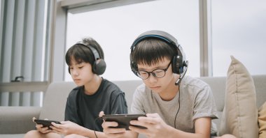 Two children playing multiplayer online games with headsets using smartphones, Dec. 9, 2020. (Getty Images Photo)