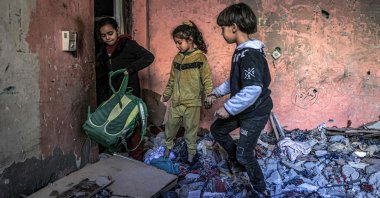 Children inspect items in the rubble in a room overlooking a building destroyed by Israeli bombardment, Rafah, southern Gaza Strip, Palestine, Dec. 24, 2023. (AFP Photo)