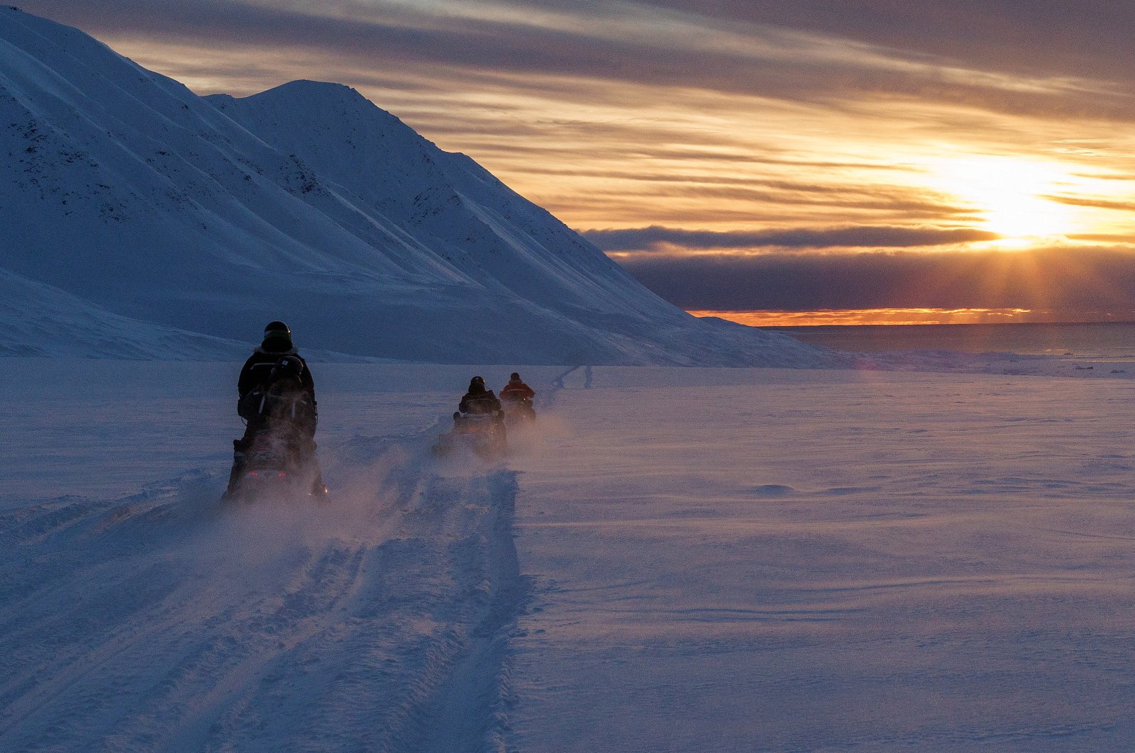 Scientists drive their snowmobiles across the Arctic toward Kongsfjord during sunset near Ny-Alesund, Svalbard, Norway, April 10, 2023. (Reuters Photo)