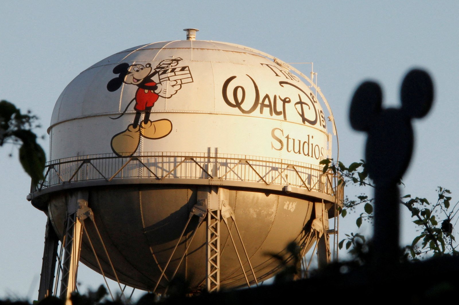 The water tower at The Walt Disney Co., featuring the character Mickey Mouse, is seen behind a silhouette of mouse ears on the fencing surrounding the company&#039;s headquarters in Burbank, California, U.S., Feb. 7, 2011. (Reuters Photo)