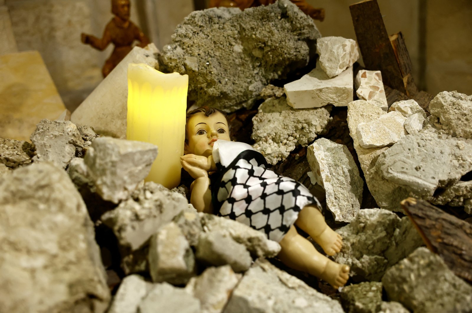 An installation shows a figure symbolizing baby Jesus lying amidst the rubble in a reference to Gaza, Bethlehem, occupied West Bank, Palestine, Dec. 24, 2023. (Reuters Photo)