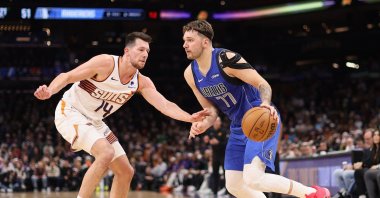Dallas Mavericks' Luka Doncic (R) handles the ball under pressure from Phoenix Suns' Drew Eubanks during the first half of the NBA game at Footprint Center, Phoenix, U.S., Dec. 25, 2023. (AFP Photo)