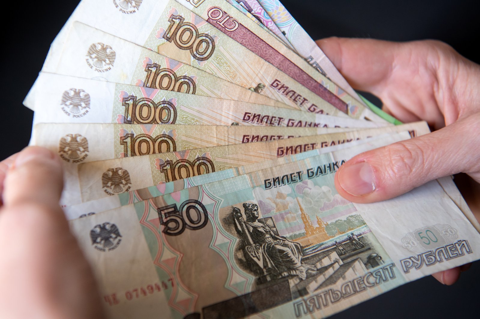 A woman holds Russian ruble banknotes in her hands in this photo dated Feb. 28, 2022. (Reuters Photo)