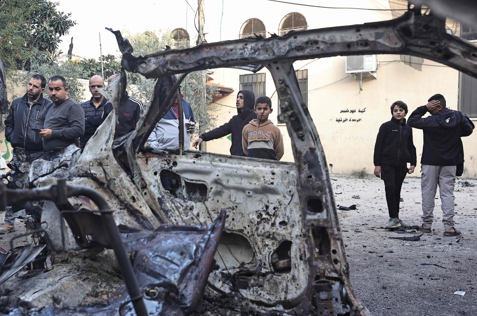 Palestinians inspect the remains of a burnt vehicle in the aftermath of an Israeli raid in the Nur Shams refugee, Tulkarem, occupied West Bank, Palestine, Dec. 27, 2023. (AFP Photo)