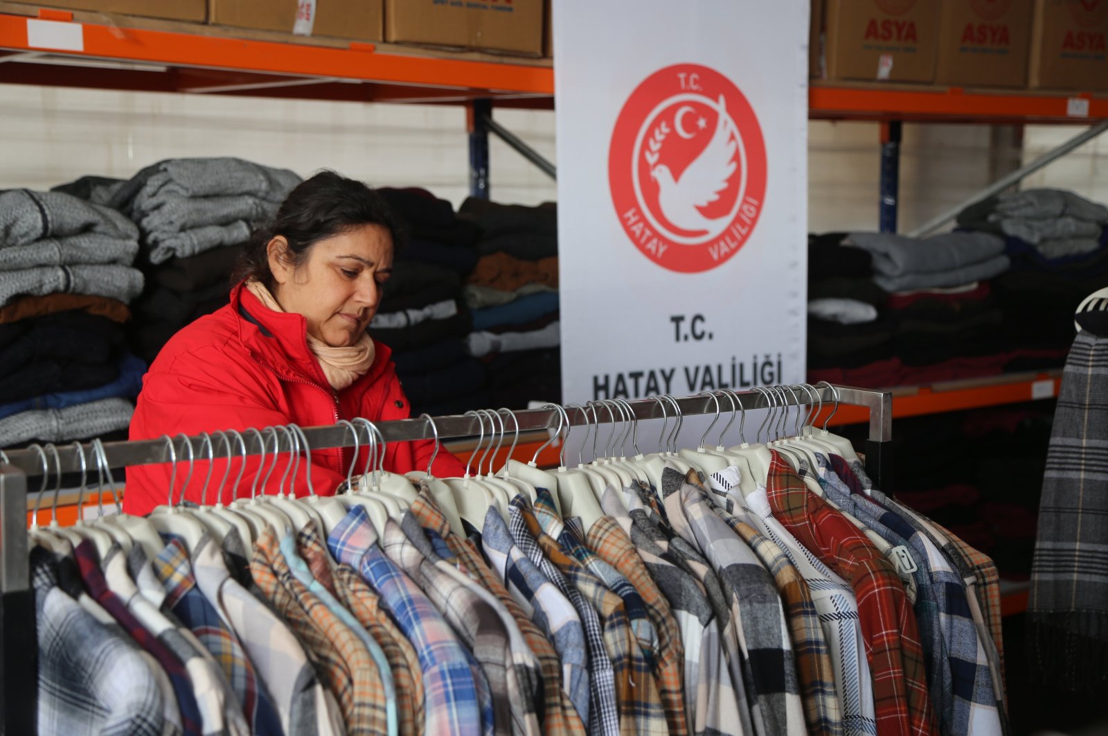 A volunteer organizes clothing in a donation warehouse, central Antakya, Hatay, Türkiye, Dec. 29, 2023. (AA Photo)