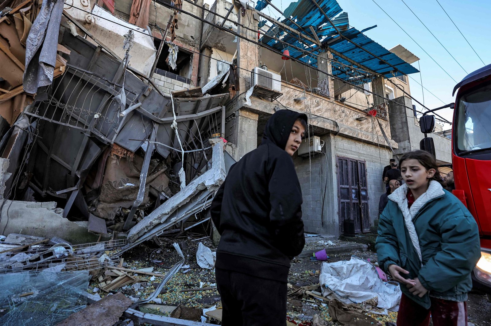 Children stand before a building heavily damaged in an Israeli raid, Nur Shams refugee camp, Tulkarem, occupied West Bank, Palestine, Dec. 26, 2023. (AFP Photo)