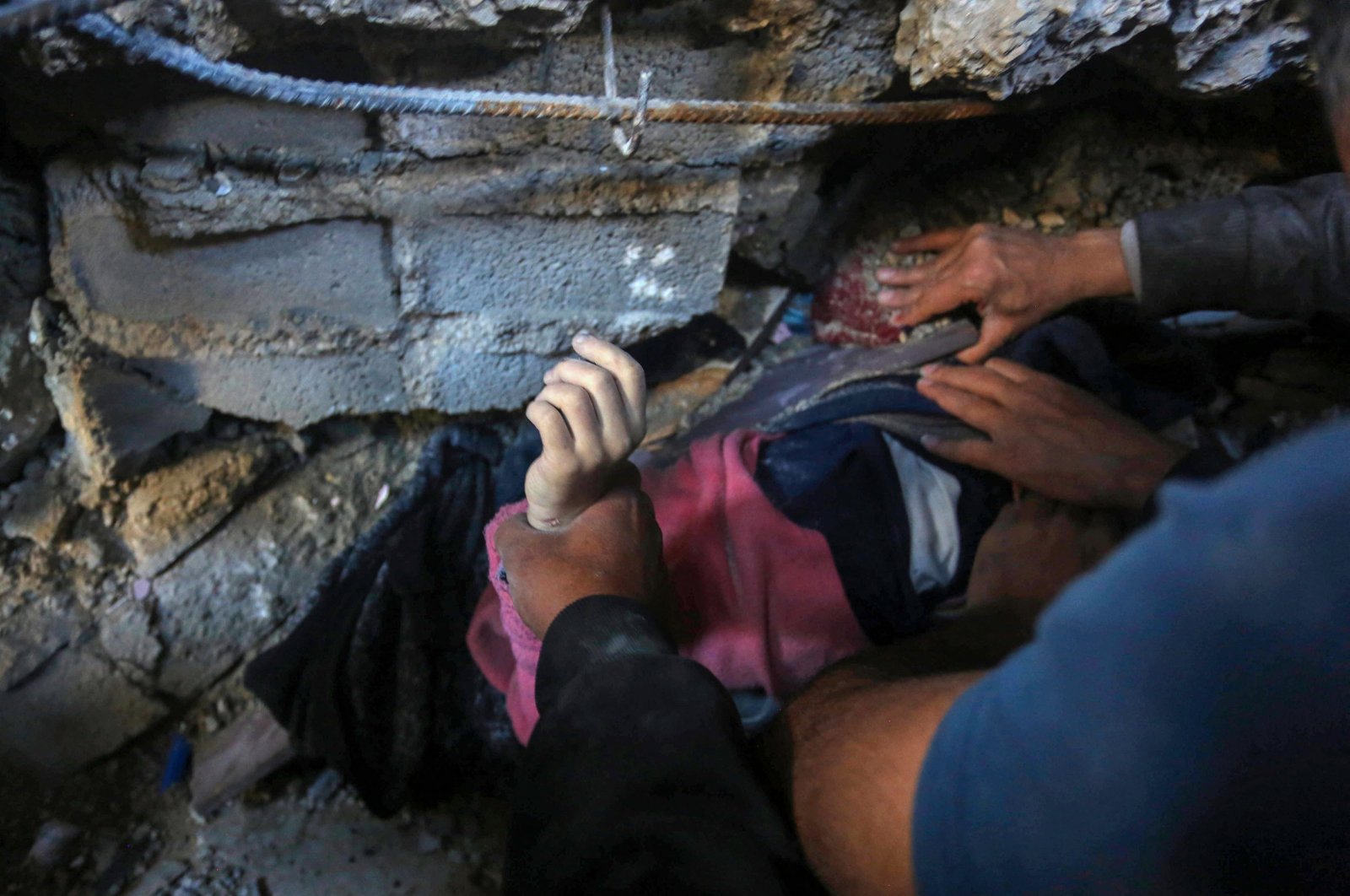 Palestinians try to unearth the body of a child following an Israeli strike on the Zawayda area of the central Gaza Strip on Dec. 30, 2023. (AFP Photo)