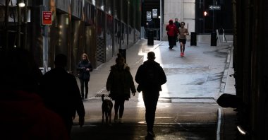 People walk through the Financial District by the New York Stock Exchange (NYSE) on the last day of trading for the year, in New York City, U.S., Dec. 29, 2023. (AFP Photo)