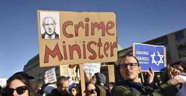 People protest with a sign reading &quot;crime minister&quot; at a demonstration at the Brandenburg Gate in Berlin against the judicial reform of Israel&#039;s Prime Minister Benjamin Netanyahu who was on a visit in Berlin, Germany, March 16, 2023. (AP File Photo)