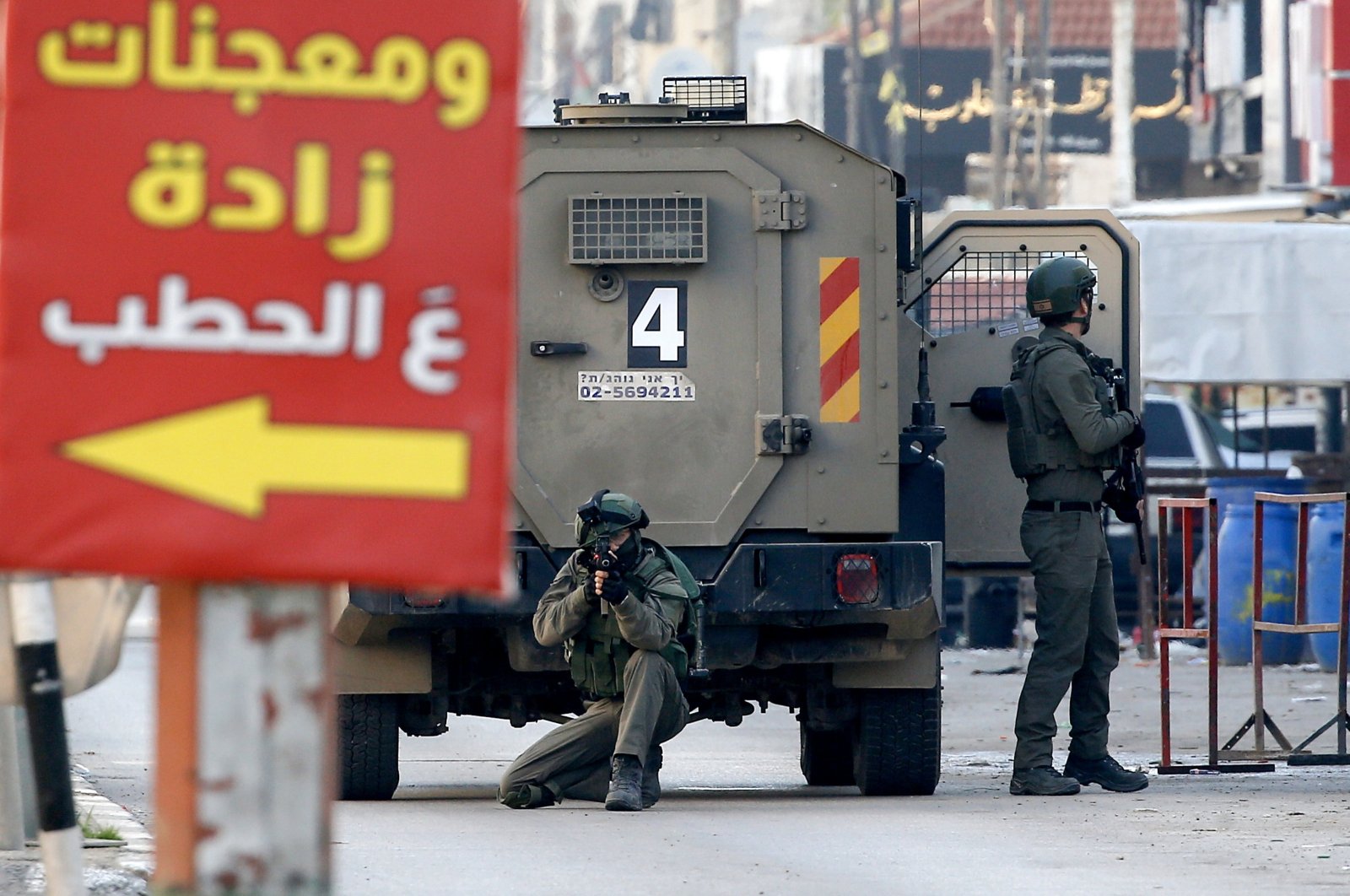 Israeli soldiers aim their guns while standing next to a military vehicle during an Israeli army raid at the Askar refugee camp, on the outskirts of the occupied West Bank city of Nablus, Palestine, Dec. 31, 2023. (EPA Photo)