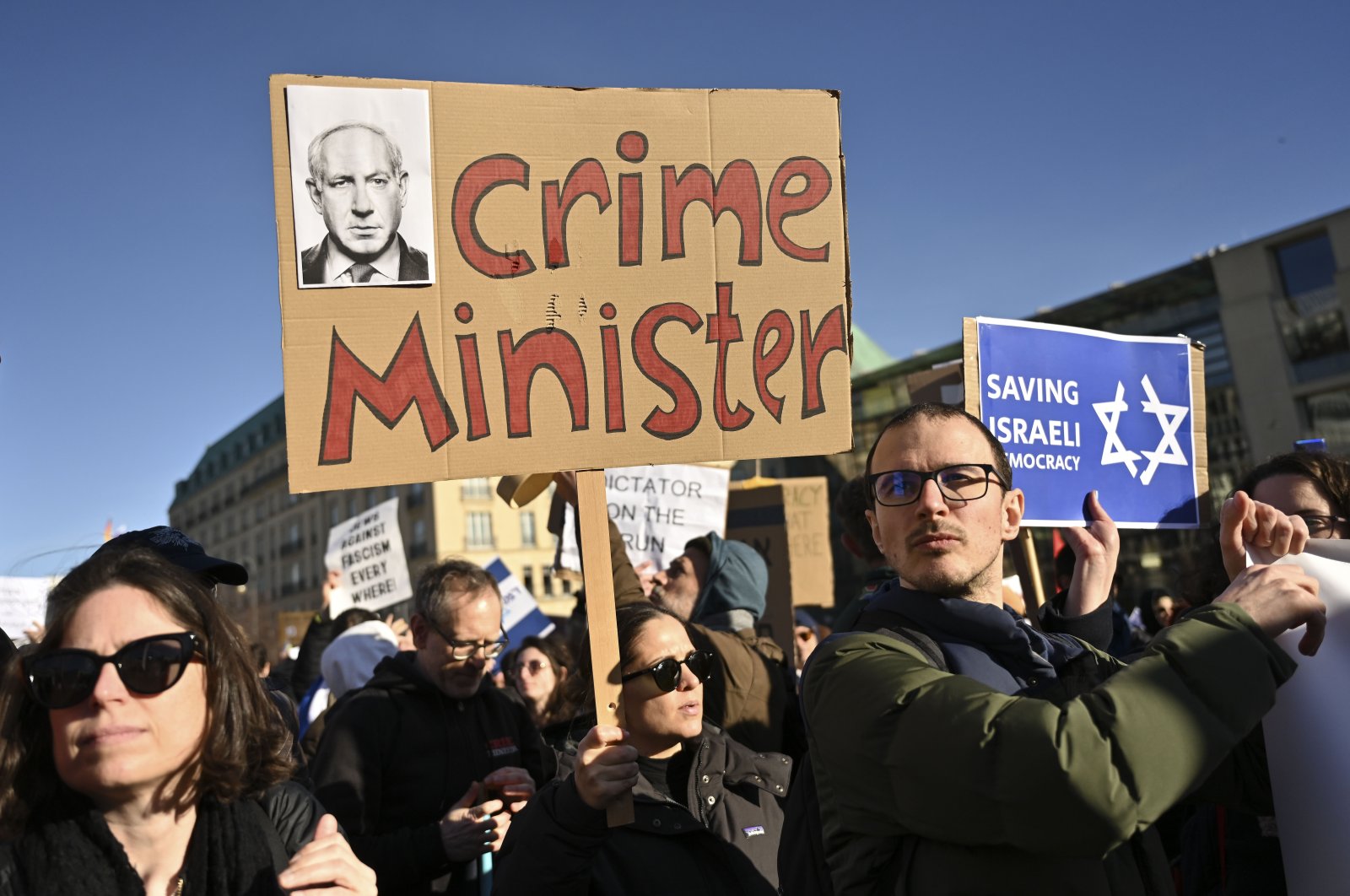 People protest with a sign reading &quot;crime minister&quot; at a demonstration at the Brandenburg Gate in Berlin against the judicial reform of Israel&#039;s Prime Minister Benjamin Netanyahu who was on a visit in Berlin, Germany, March 16, 2023. (AP File Photo)