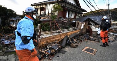 Firefighters inspect collapsed wooden houses in Wajima, Ishikawa prefecture, Japan, Jan. 2, 2024. (AFP Photo)