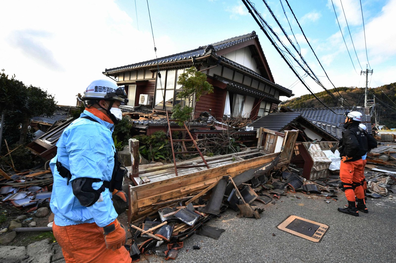 Firefighters inspect collapsed wooden houses in Wajima, Ishikawa prefecture, Japan, Jan. 2, 2024. (AFP Photo)