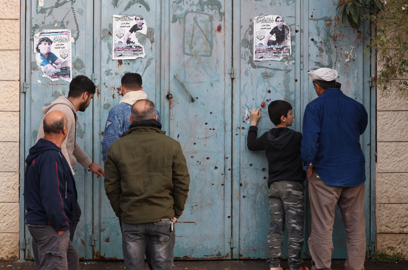 Palestinian residents look at bullet holes at the location where four Palestinians were killed by Israeli army, Azoun village Near Qalqilya, occupied West Bank, Jan. 2, 2024. (EPA Photo)