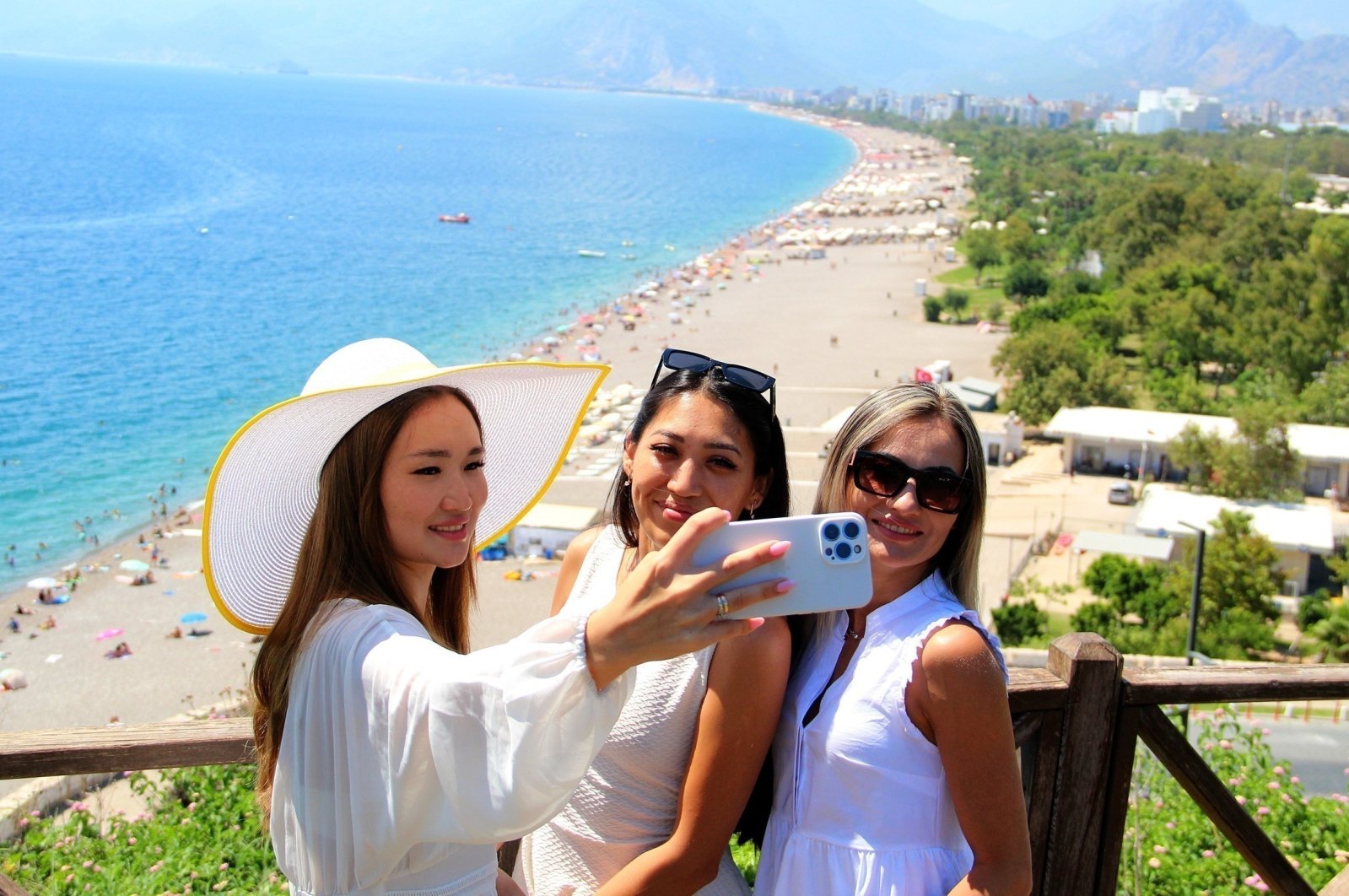 Tourists take a photo with a beach in the background in Antalya, southern Türkiye, Aug. 31, 2022. (IHA Photo)