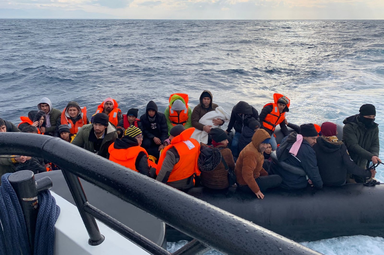 Turkish coast guard pulls up next to a rubber boat to rescue some 55 irregular migrants pushed back by Greece on their way to the island of Lesbos, off the coast of western Balıkesir province, Türkiye, Jan. 2, 2024. (AA Photo)