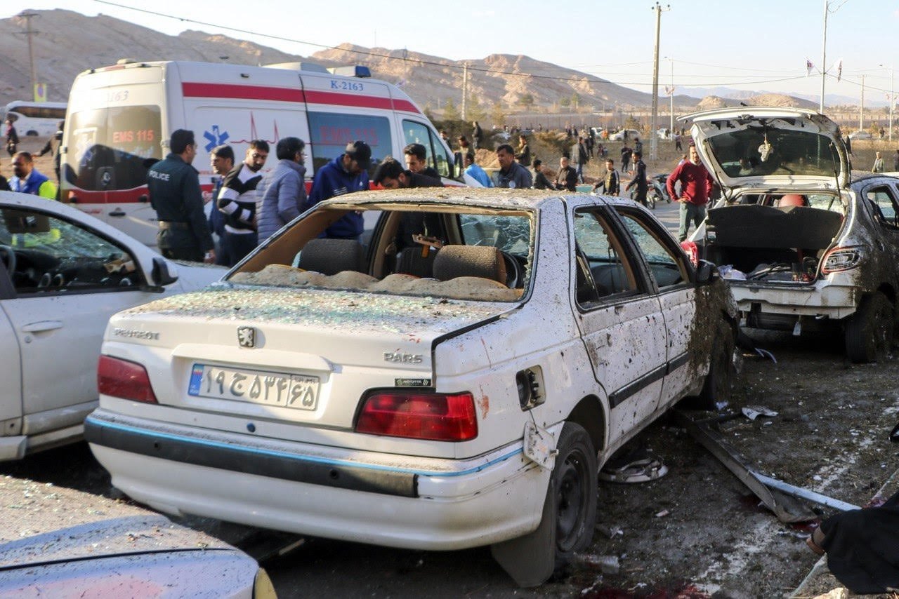 Damaged cars are seen as people try to help victims after an explosion Kerman, Iran, Jan. 3, 2024. (EPA Photo)