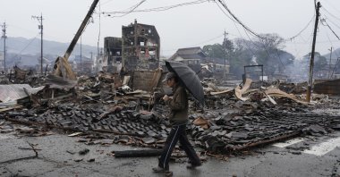 A man walks past burnt remains of a building following an earthquake in Wajima, Ishikawa Prefecture, Japan, Jan. 3, 2024. (EPA Photo)