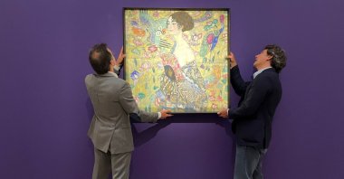 Employees pose with an artwork entitled&quot;Lady with a Fan&quot; by Austrian artist Gustav Klimt, during a photocall at Sotheby&#039;s auction house in central London, U.K., June 20, 2023. (Reuters Photo)
