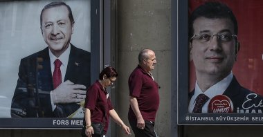 People walk past posters of President Recep Tayyip Erdoğan and Istanbul Mayor Ekrem Imamoğlu, the CHP's candidate for the 2024 municipal election, Istanbul, Türkiye, June 4, 2019. (AP Photo)