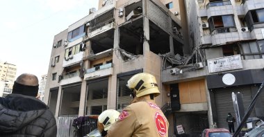 Members of the Civil Defense stand in front of the building hit by a drone strike in the southern suburb of Beirut, Lebanon, Jan. 3, 2024. (EPA Photo)