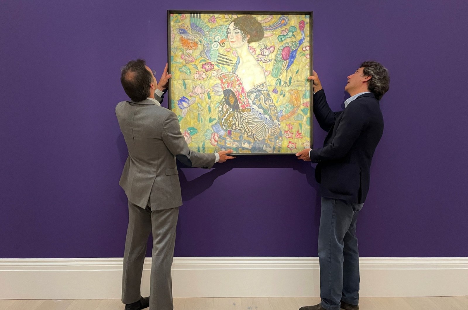 Employees pose with an artwork entitled&quot;Lady with a Fan&quot; by Austrian artist Gustav Klimt, during a photocall at Sotheby&#039;s auction house in central London, U.K., June 20, 2023. (Reuters Photo)
