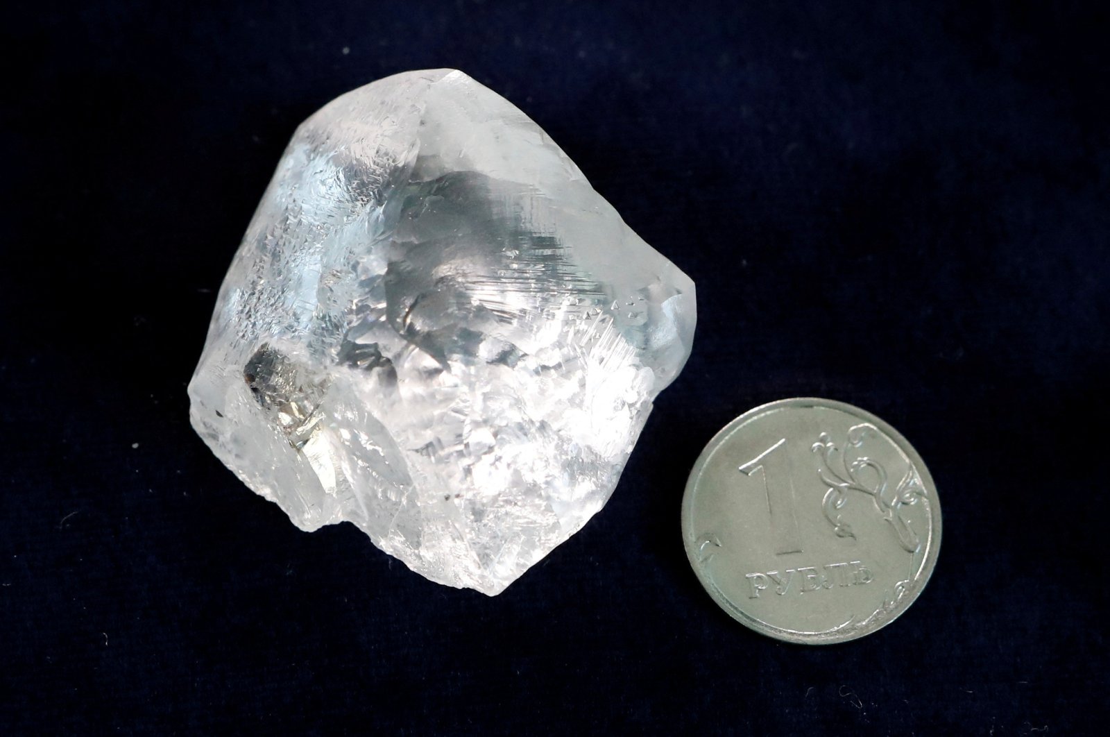 A rough diamond is seen next to a one-rouble coin at the polishing affiliate of Russian diamond producer Alrosa in Moscow, Russia, Feb. 12, 2018. (Reuters Photo)