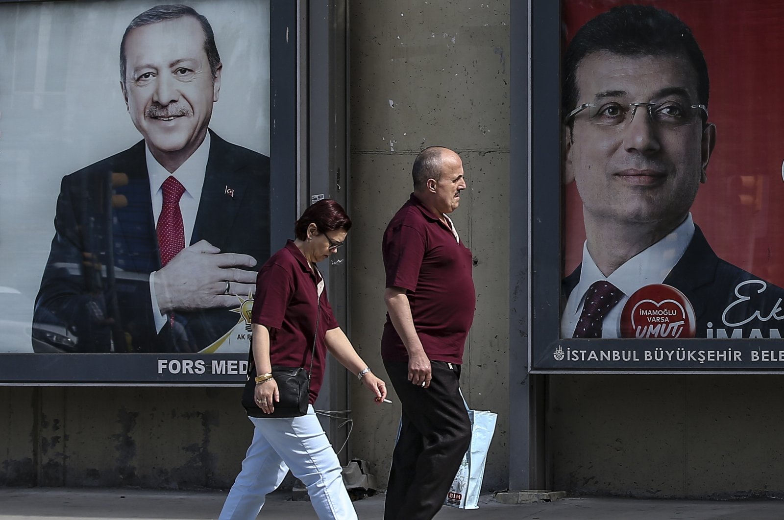 People walk past posters of President Recep Tayyip Erdoğan and Istanbul Mayor Ekrem Imamoğlu, the CHP&#039;s candidate for the 2024 municipal election, Istanbul, Türkiye, June 4, 2019. (AP Photo)