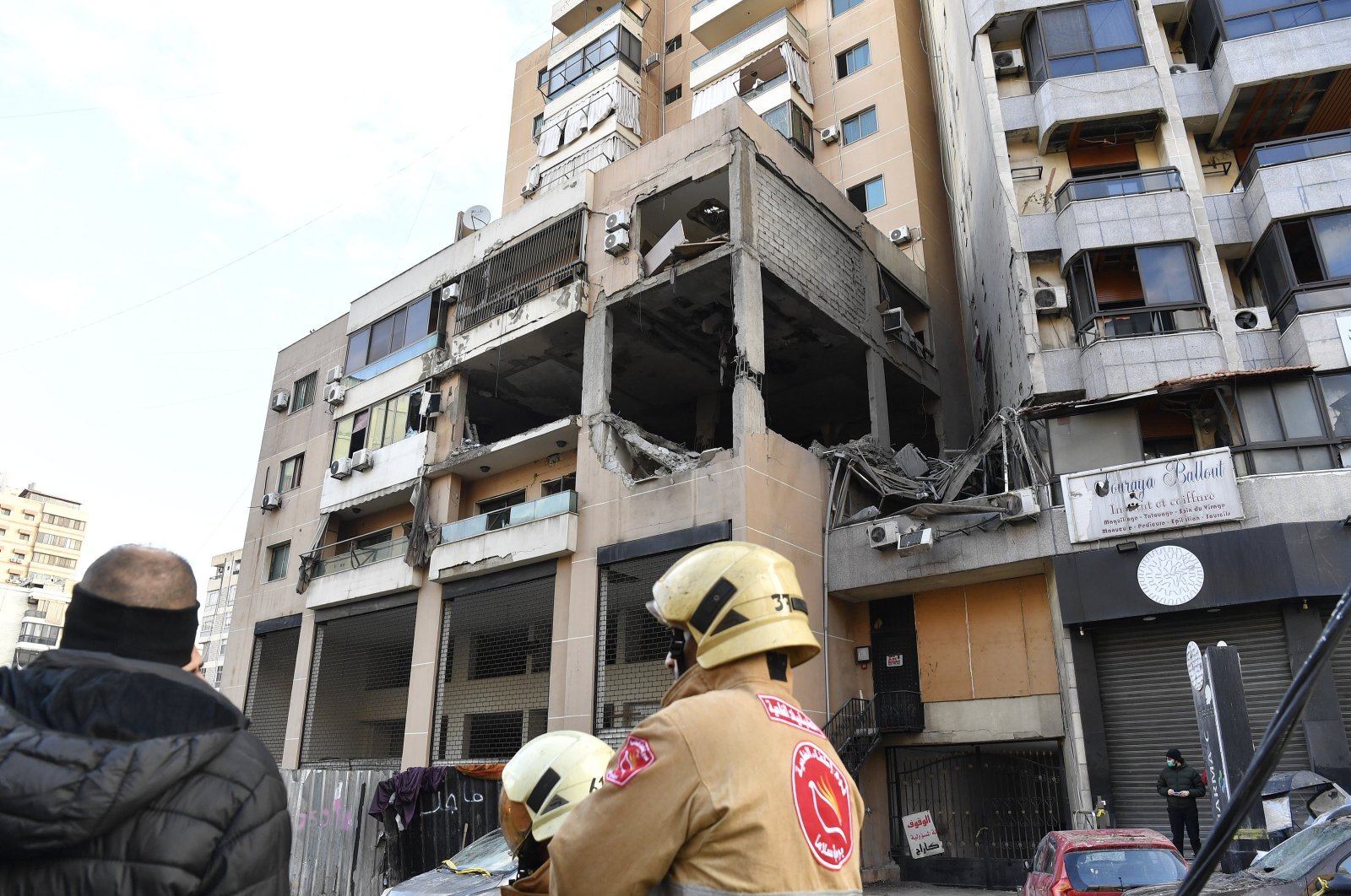 Members of the Civil Defense stand in front of the building hit by a drone strike in the southern suburb of Beirut, Lebanon, Jan. 3, 2024. (EPA Photo)