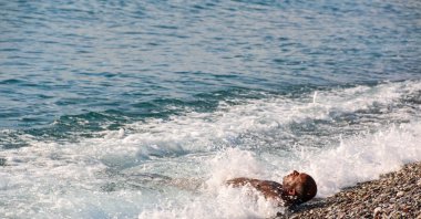 Citizen enjoys beaching in cold weather as the sea temperature remains warmer in Antalya, Türkiye, Jan. 04, 2024. (IHA Photo)