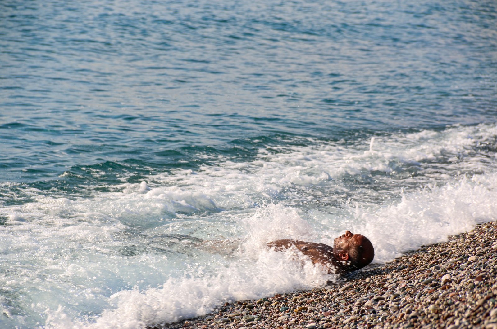 Citizen enjoys beaching in cold weather as the sea temperature remains warmer in Antalya, Türkiye, Jan. 04, 2024. (IHA Photo)